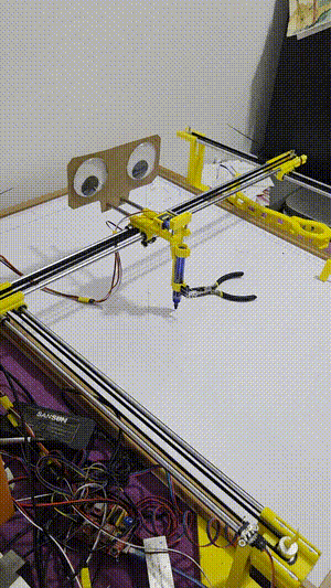 Pen plotter prototype drawing on a whiteboard while my kitten supervises.